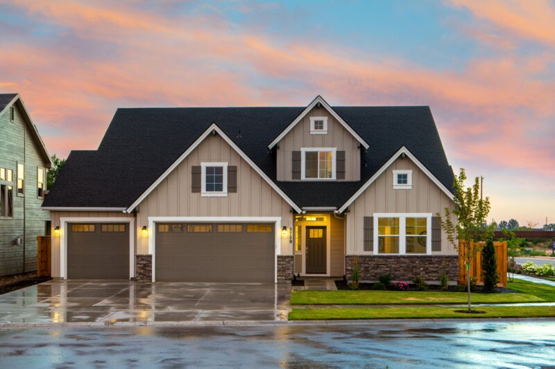 A two story house with a rain-soaked driveway featuring sign lights at dusk - Shop C2CLights.com.